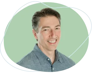 Meet Joe Dillon | Equitable Mediation Professional portrait of mediator Joe Dillon seated at a conference table with a warm, reassuring smile, ready to guide you through an amicable divorce process. For compassionate support, call Equitable Mediation at (877) 732-6682 today.